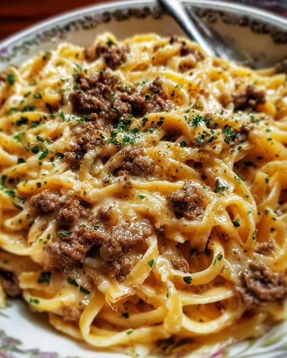 Creamy garlic butter pasta topped with ground beef and herbs