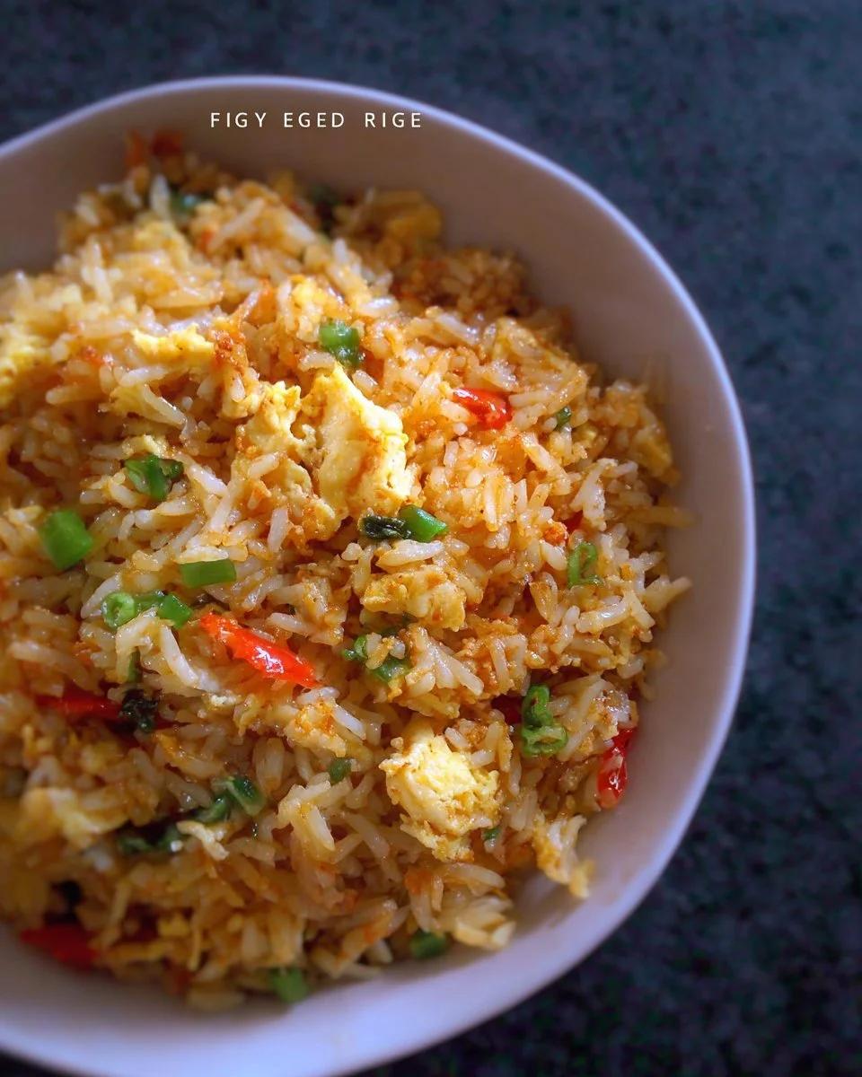 Plate of golden egg fried rice garnished with green onions and vegetables