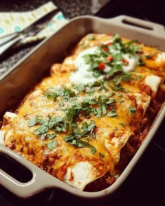Plate of homemade ground beef enchiladas topped with cheese and salsa