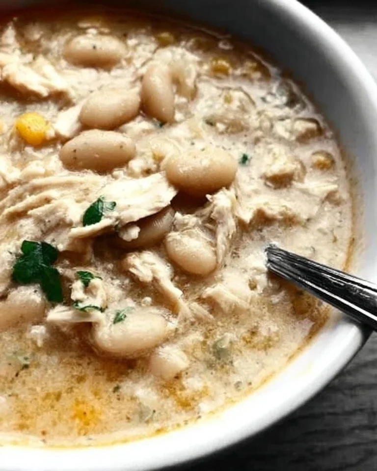 Bowl of creamy white chicken chili topped with cilantro and lime.