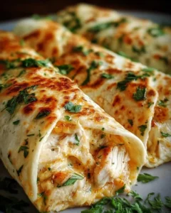 Cheesy chicken garlic wraps displayed on a wooden table with fresh herbs.