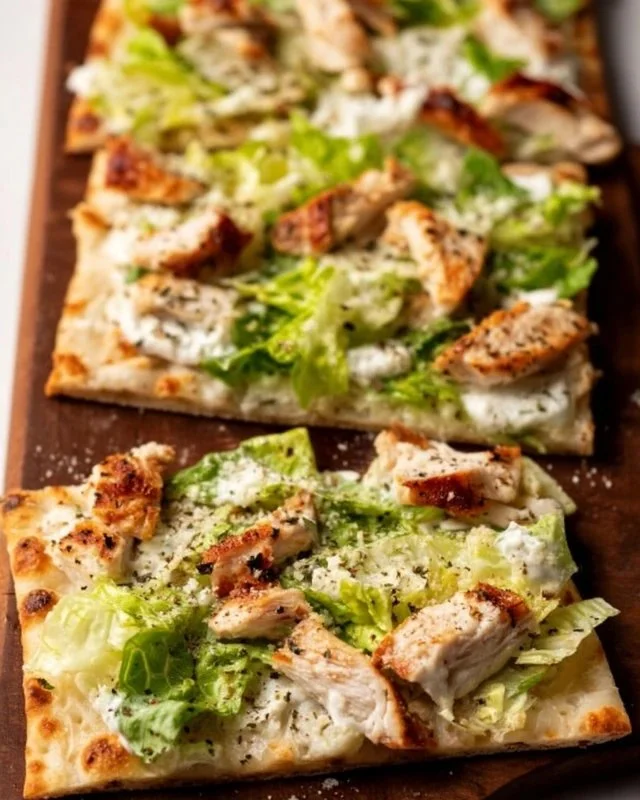 Chicken Caesar Flatbread with fresh ingredients and dressing on a wooden plate