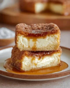 Delicious churro cheesecake topped with cinnamon sugar and caramel drizzle