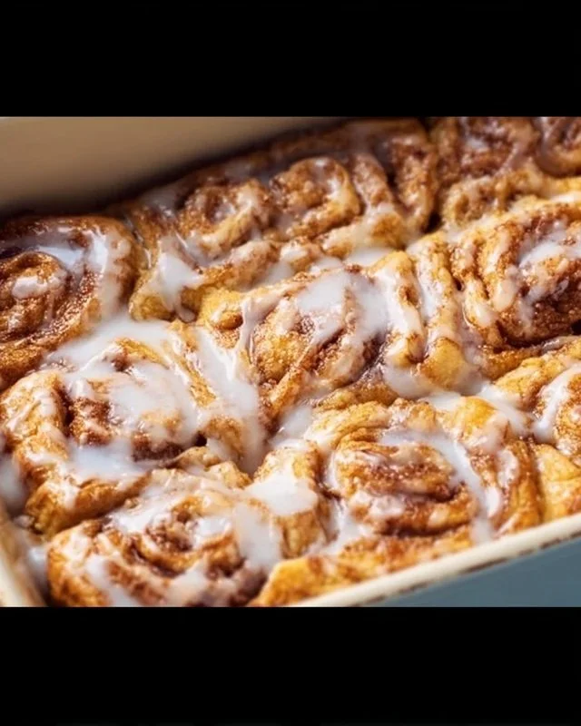 Cinnamon Roll Breakfast Bake topped with icing and cinnamon, served in a dish