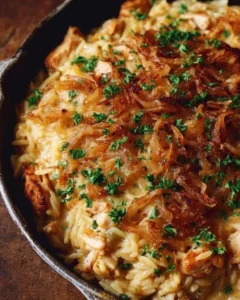 Delicious French Onion Chicken Orzo Casserole topped with melted cheese and herbs