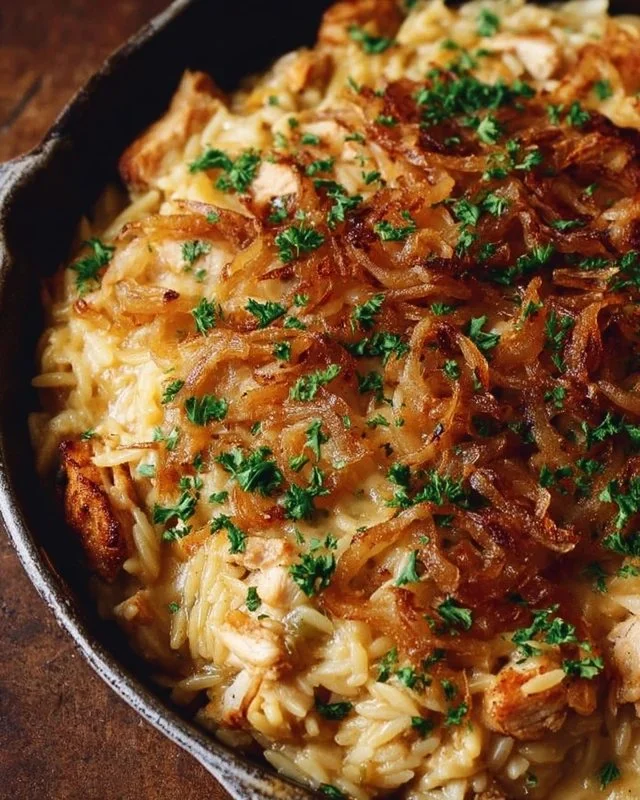 Delicious French Onion Chicken Orzo Casserole topped with melted cheese and herbs