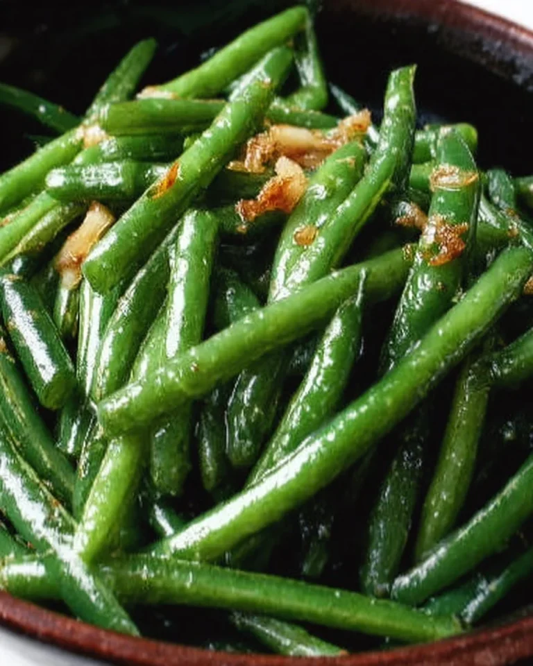 Garlic butter sautéed green beans on a plate, garnished and ready to serve.
