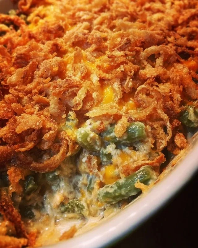 A bowl of Grandma's green bean casserole topped with crispy onions.