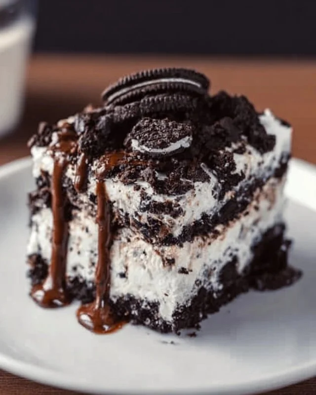 Delicious Oreo Poke Cake topped with crushed Oreos and chocolate frosting