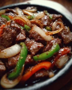 Sizzling Chinese pepper steak with onions on a plate