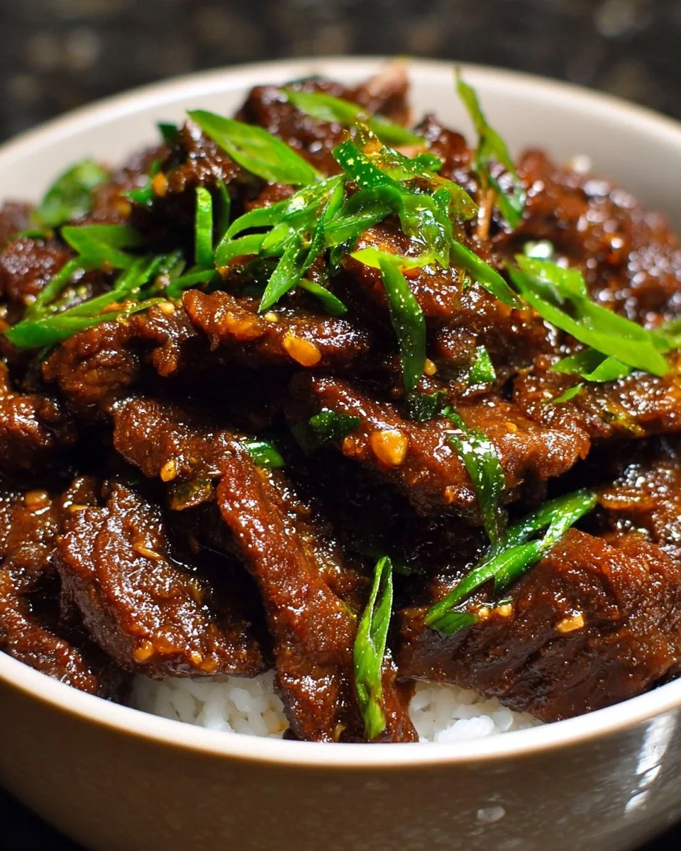 Delicious Slow Cooker Mongolian Beef served with rice and vegetables.