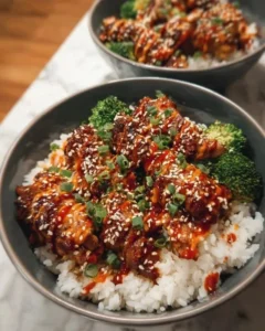 Sticky chicken rice bowls topped with fresh vegetables and herbs