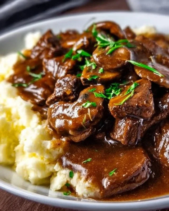 Delicious beef tips served with rich, savory gravy over a bed of mashed potatoes.