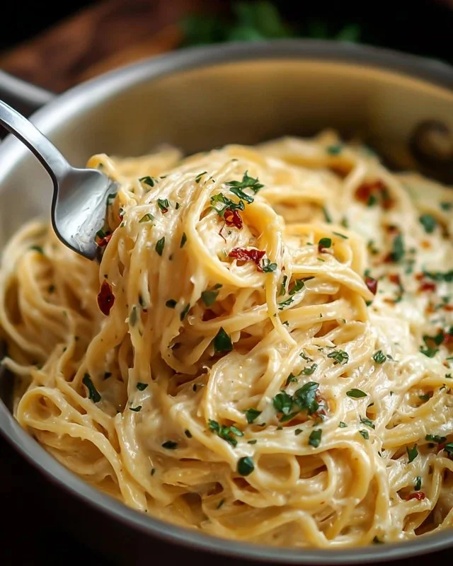 Cheesy garlic parmesan spaghetti served in a bowl with grated cheese on top