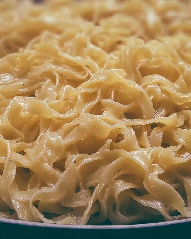 Bowl of creamy cafeteria noodles topped with fresh herbs