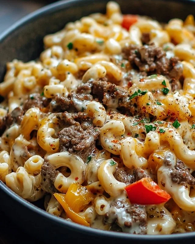 High-protein creamy Philly cheesesteak mac and cheese dish with vibrant toppings.