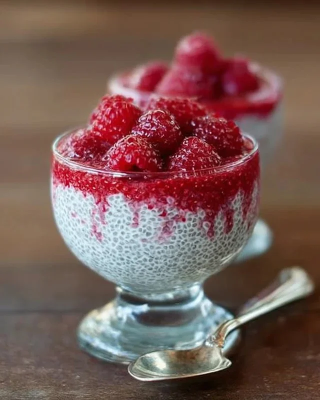 Vanilla raspberry chia pudding topped with fresh raspberries and mint leaves.