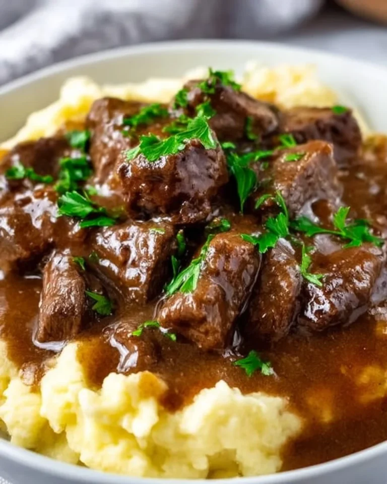 Beef tips cooked in rich gravy served on a plate