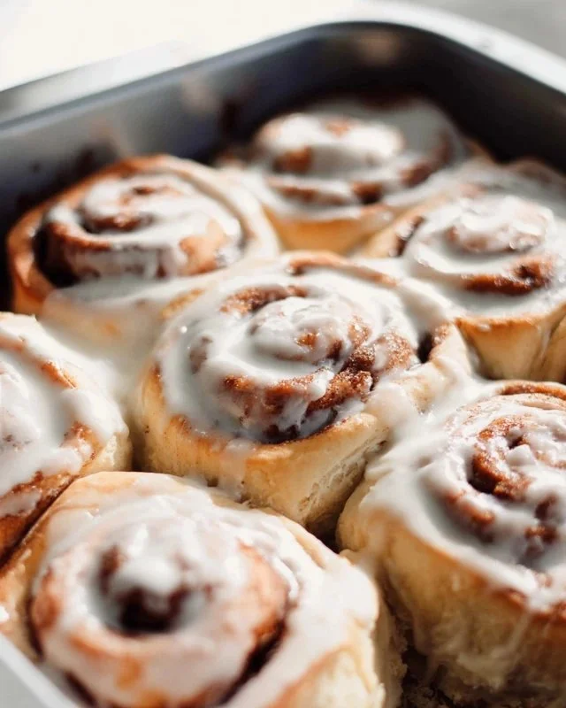 Freshly baked homemade cinnamon rolls drizzled with icing