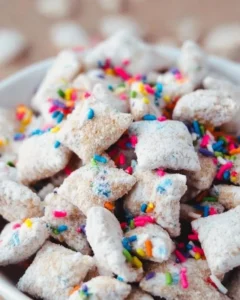 Colorful Cake Batter Puppy Chow in a bowl, perfect for a tasty snack.