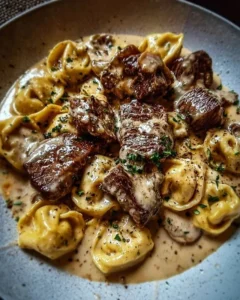 Cracked garlic steak tortellini in creamy sauce served in a bowl