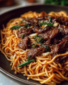 Delicious Garlic Butter Steak served over Lightning Noodles, garnished with fresh herbs.