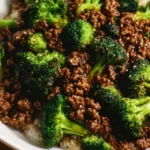 A delicious plate of ground beef and broccoli stir-fry garnished with sesame seeds.