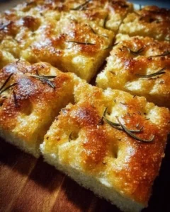 Freshly baked homemade focaccia bread topped with herbs and olive oil