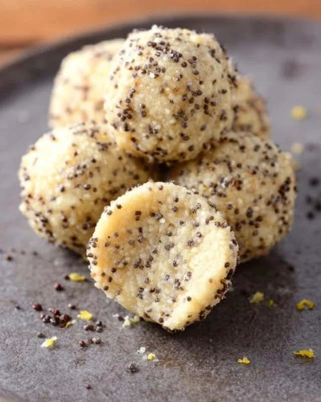 Homemade lemon poppy seed energy bites in a bowl with fresh lemons