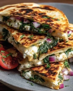 Mediterranean Quesadillas with spinach, feta, mozzarella, and red onion on a plate