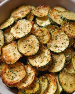 Bowl of crispy oven-baked zucchini chips with seasonings