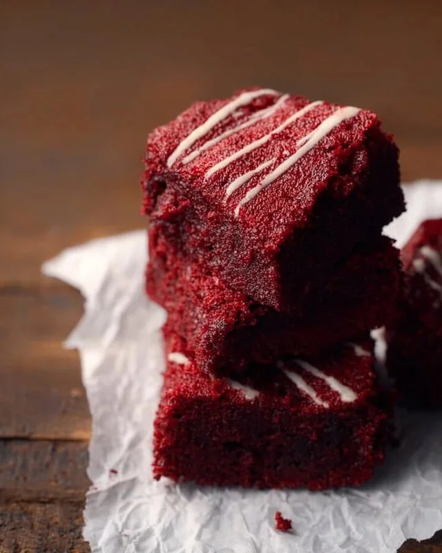 Delicious red velvet brownies with cream cheese frosting on a white plate