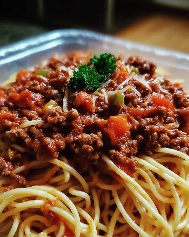 Delicious plate of spaghetti with rich meat sauce, served hot and garnished.