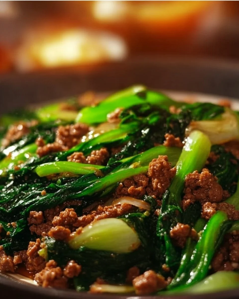 Plate of Stir-Fried Bok Choy with Ground Meat garnished with herbs.