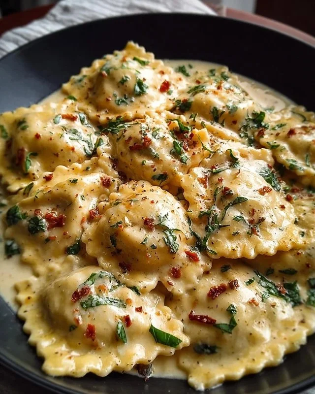 Creamy Tuscan Ravioli garnished with herbs and cheese