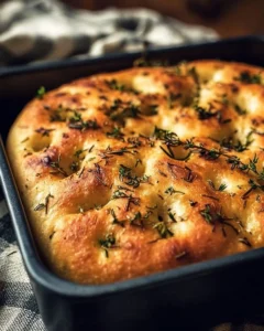 Freshly baked Herb Focaccia bread with sprigs of rosemary and thyme