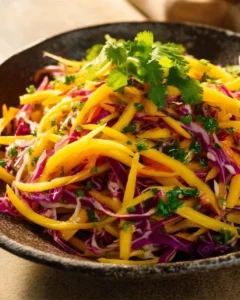 Colorful mango slaw with fresh vegetables in a bowl