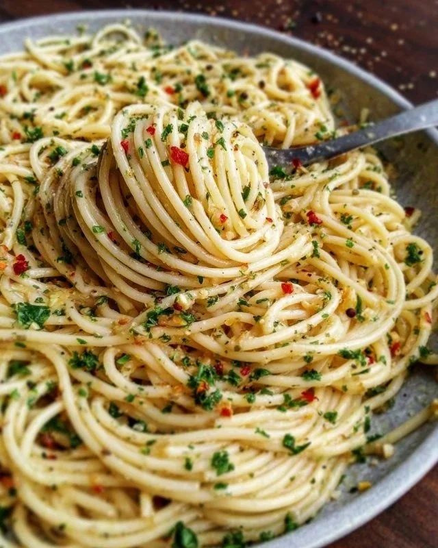 Plate of Spaghetti Aglio e Olio with garlic and olive oil, topped with parsley